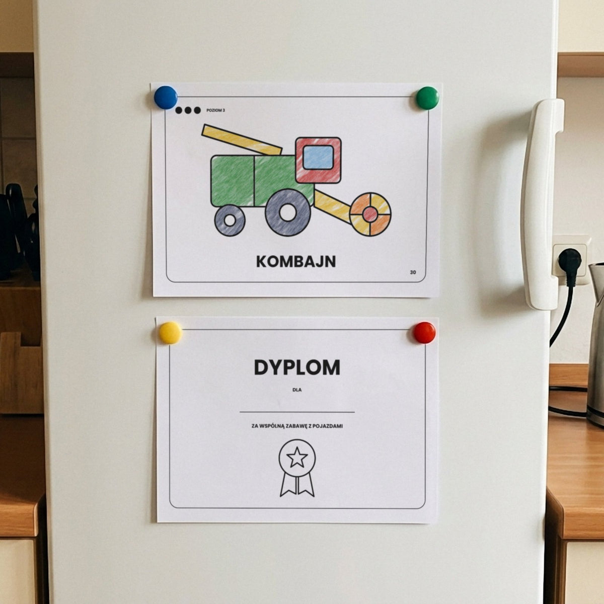 Pokolorowany kombajn i dyplom z kolorowanki Pojazdy przypięte magnesami do lodówki